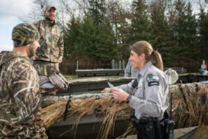 Warden Amanda Kretschmer with hunters.